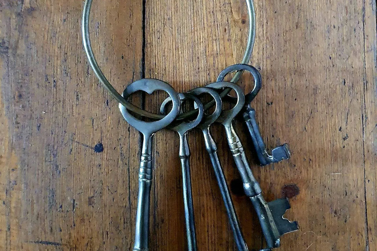 Molho de chaves antigas pendurado sobre uma mesa de madeira