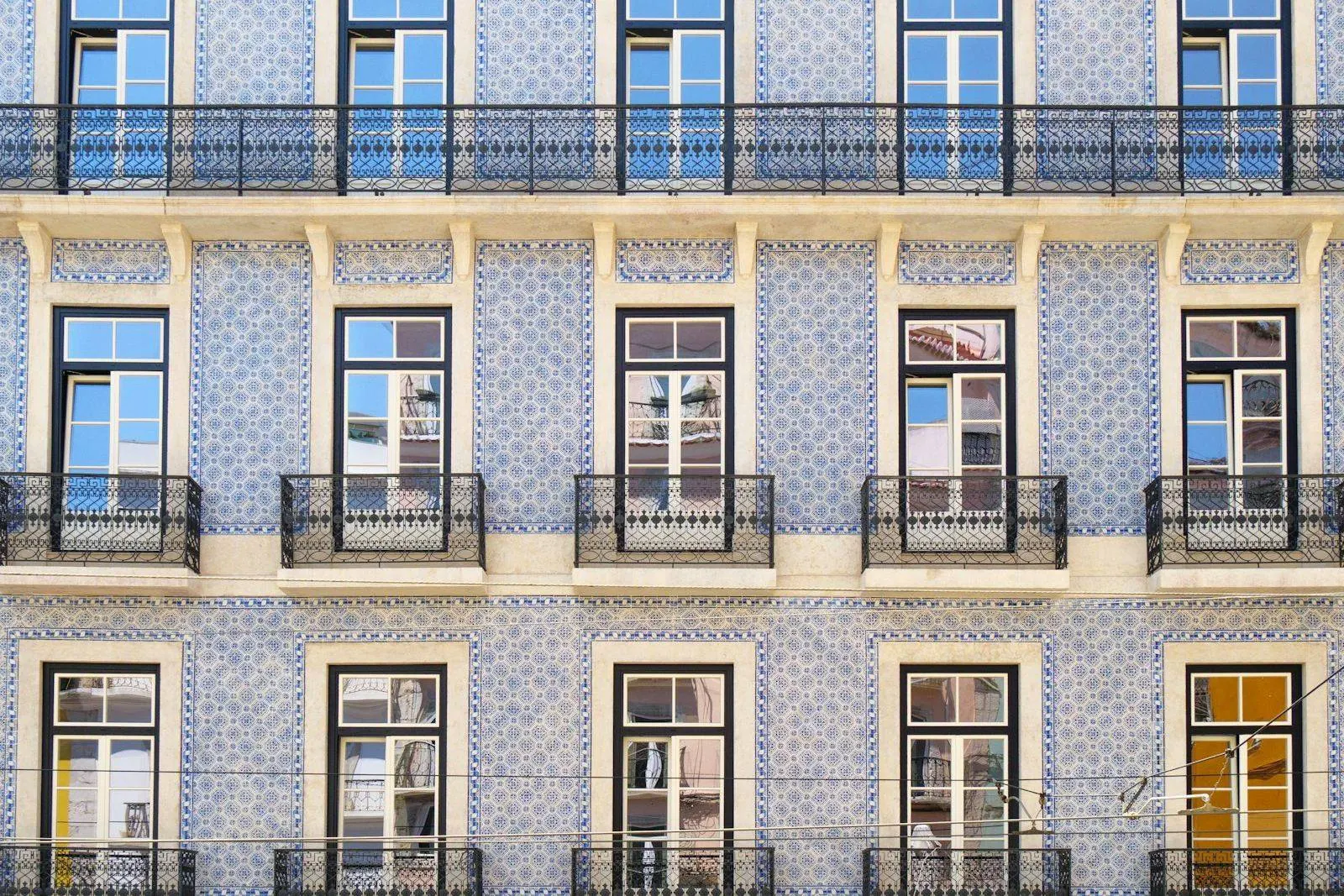 Fachada de azulejo em Lisboa com janelas e varandas de ferro
